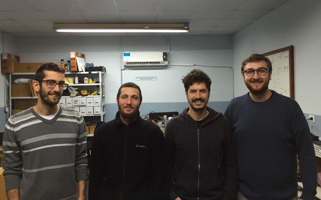 Four Equaphon staff members in the company workshop, with shelves of components behind them