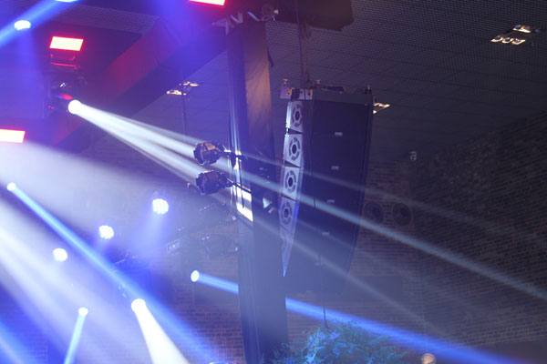 Line array hanging beside the stage, with moving-light beams