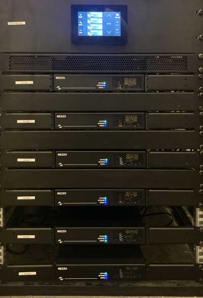 Rack with a WM Touch wall panel on top and six Mezzo amplifiers below